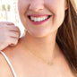 Everlasting Love Necklace on woman; two 10K yellow gold hearts with diamonds.