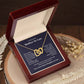 Interlocking hearts necklace for future mother-in-law in gift box on wood surface.