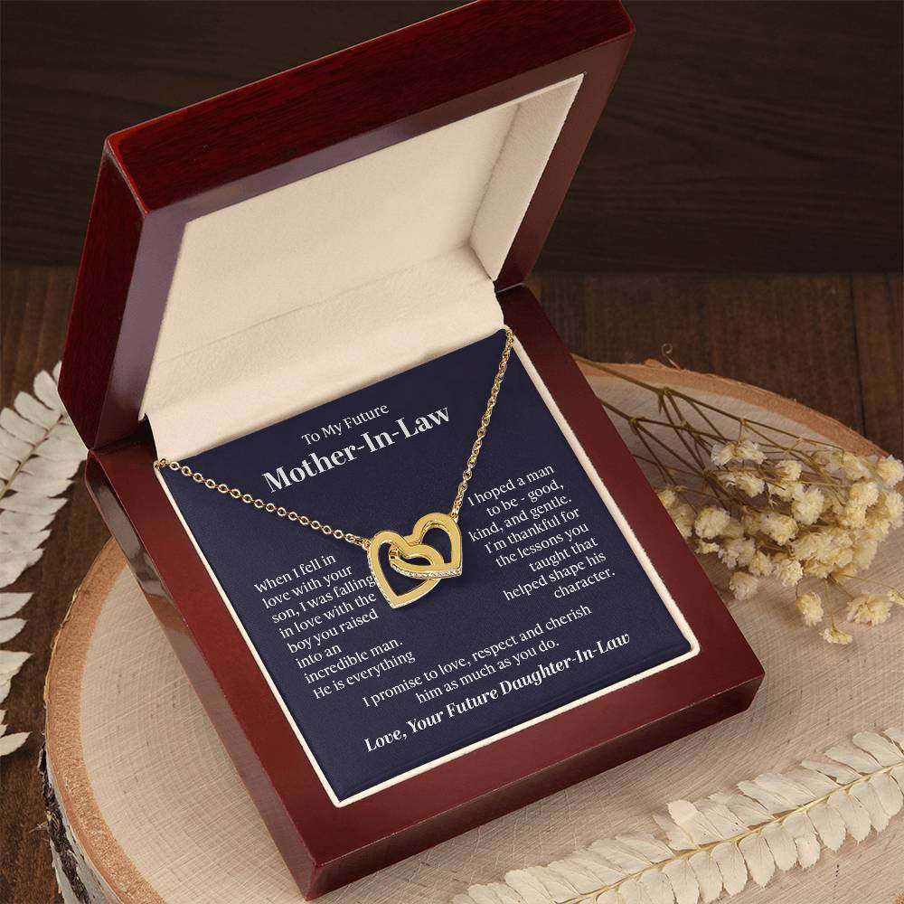 Interlocking hearts necklace for future mother-in-law in gift box on wood surface.