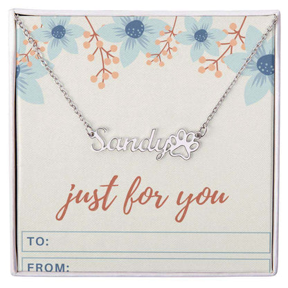 Personalized name necklace with paw print charm on floral gift card.