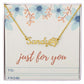 Personalized name necklace with paw print charm on floral background.
