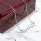 Personalized name necklace with paw print charm on red box, polished stainless steel, adjustable chain.
