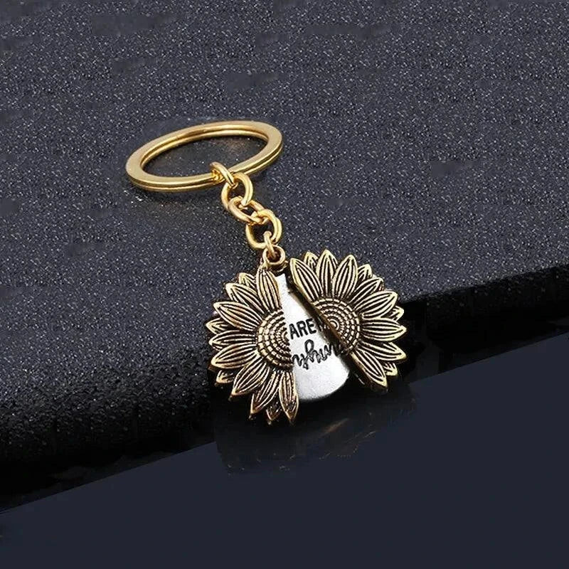 Sunflower with hidden message necklace on black background, symbolizing happiness and positivity.