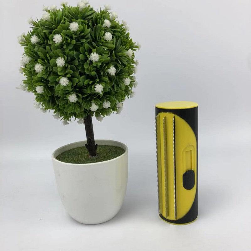 Pet Hair Remover Brush Fur-Sweep next to potted plant.