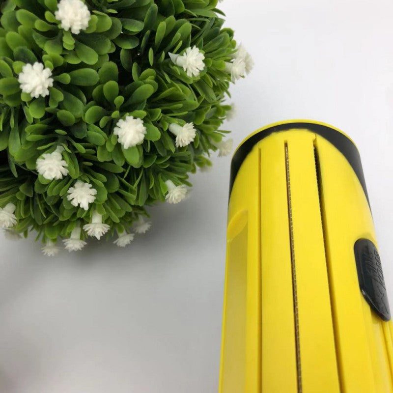 Pet Hair Remover Brush Fur-Sweep with yellow design next to greenery.