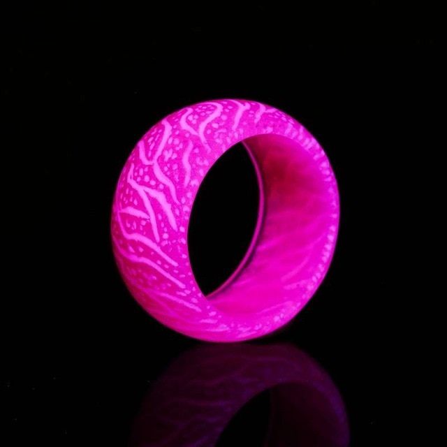 Luminous Mesmerizing pink Love Glow Ring with luminescent design on black background.