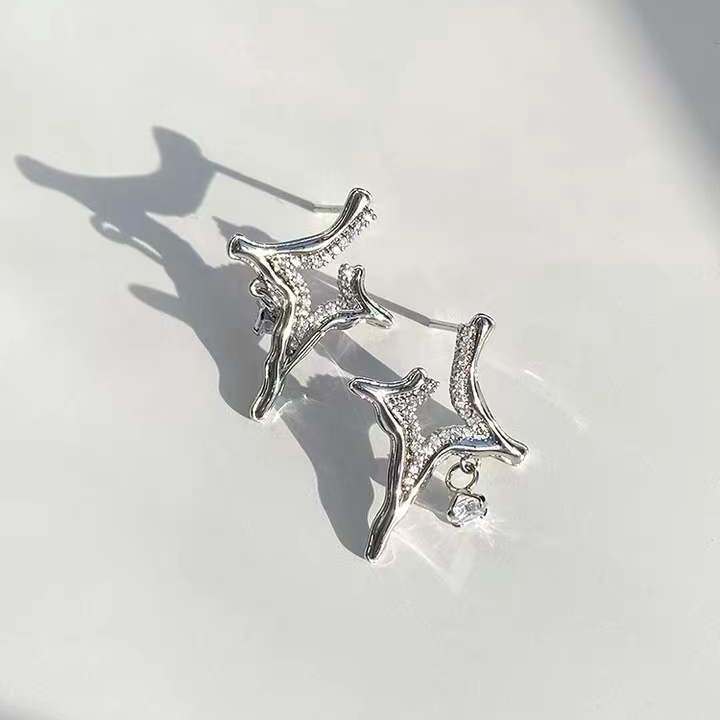 Asterism Rhinestone Earrings with geometric design and sparkling rhinestones on a light background.